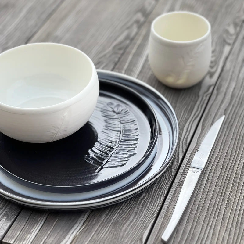 Service d'assiettes, bol et tasse en porcelaine décoré d'une plume